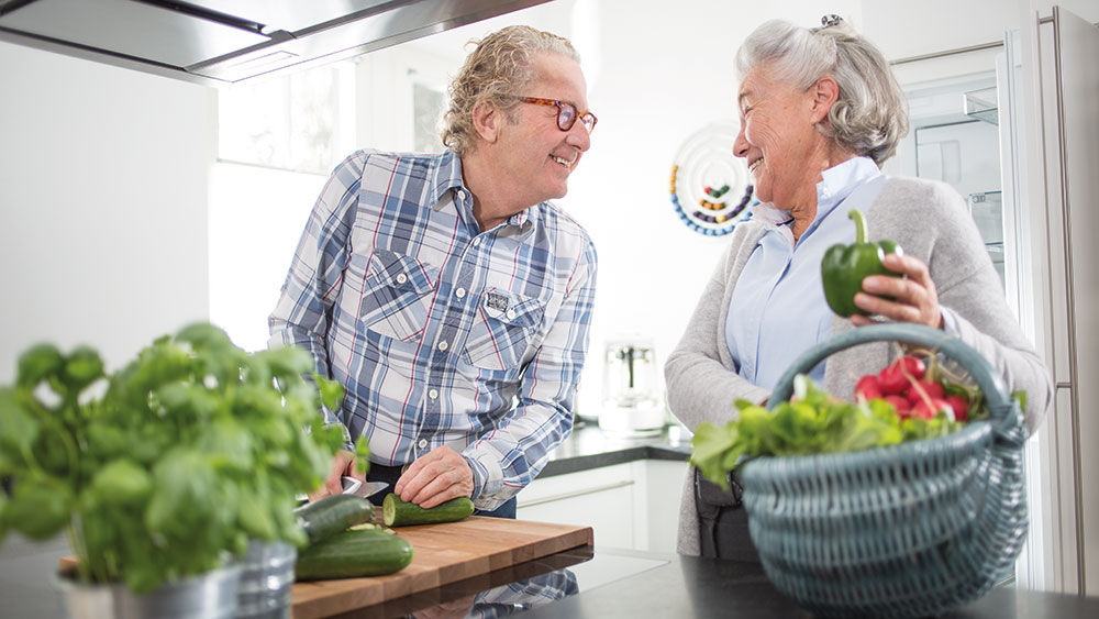 uomo e donna preparano le verdure insieme