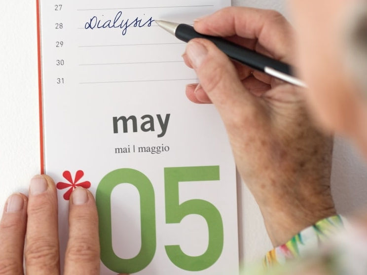 Una donna anziana prende appunti nel calendario