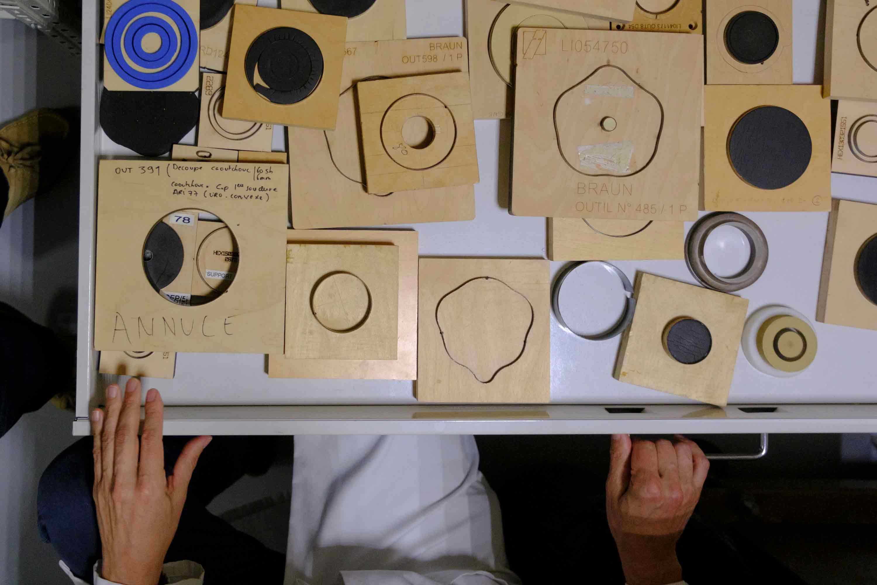 Person working with wooden templates and molds at a table