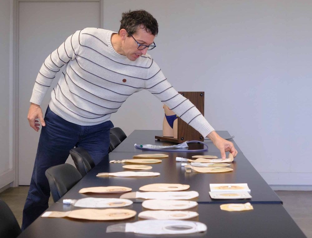 A man sorts stoma bags on a table