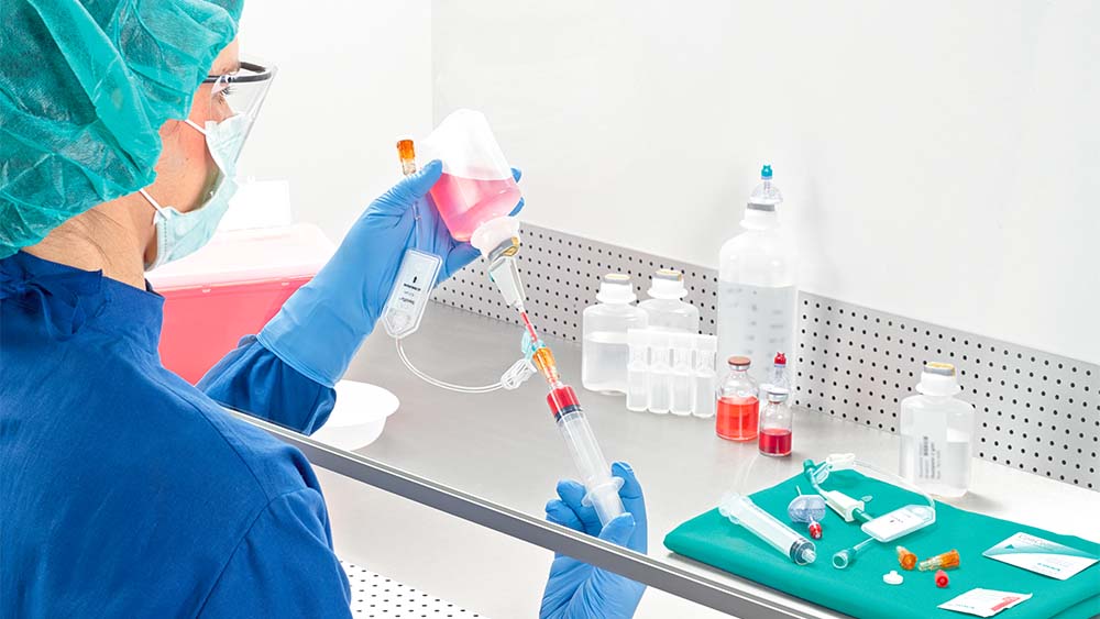 Una farmacista tira la siringa sotto il flusso d'aria laminare