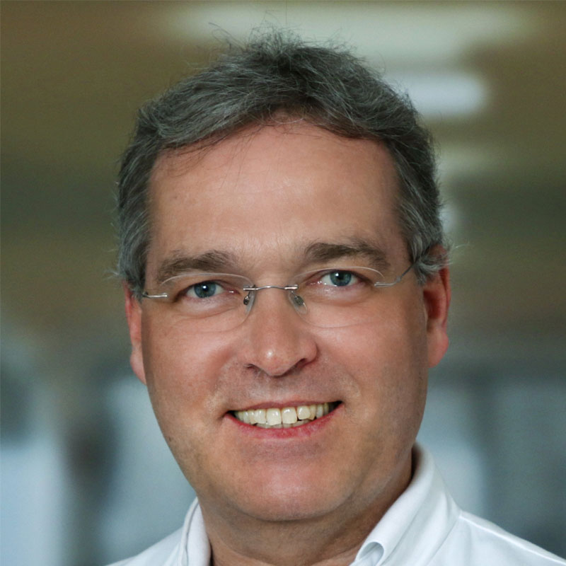 Portrait of Professor Doctor Markus Golling in a docotor‘s coat smiling confidently into the camera